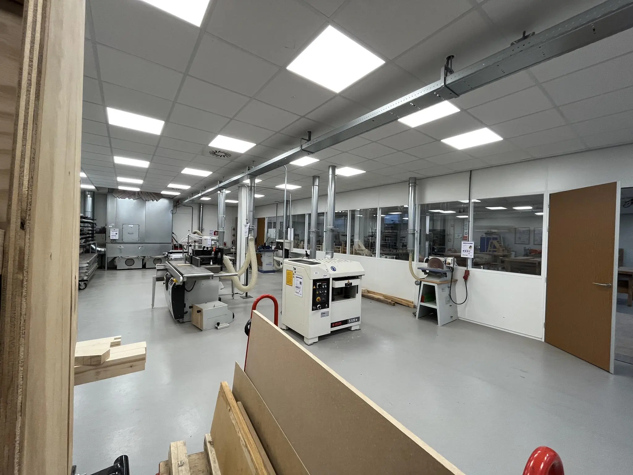 Moderne houtbewerkingswerkplaats aan de Niels Bohrweg met diverse machines en afzuiginstallaties.